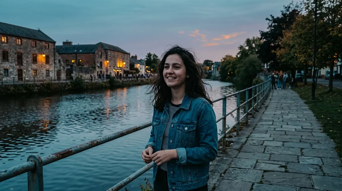 Jeune femme souriante en veste jean au cr&eacute;puscule pr&egrave;s d'une rivi&egrave;re