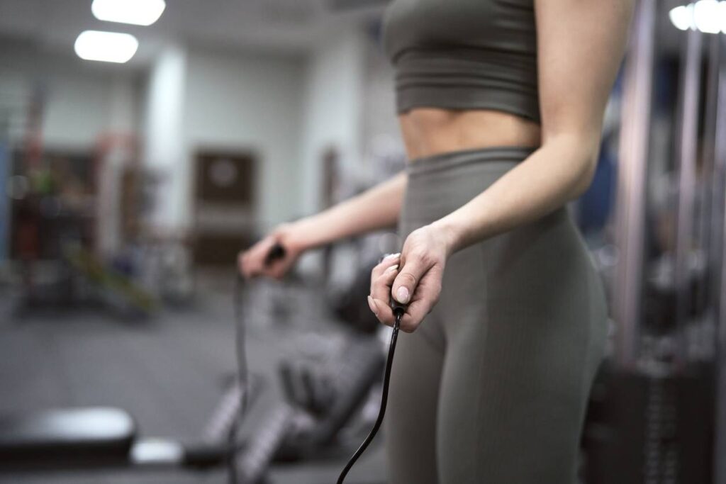 femme en tenue de sport utilisant une corde à sauter pour faire du crossfit